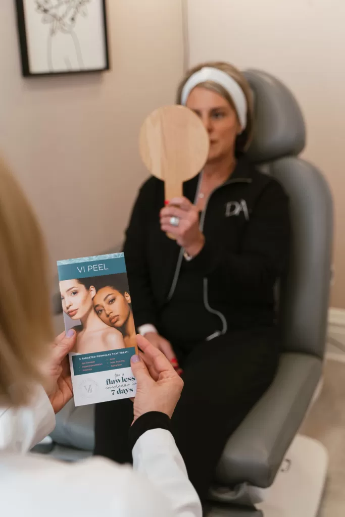 patient looking at her results of VI Peel treatment at Direct Aesthetics