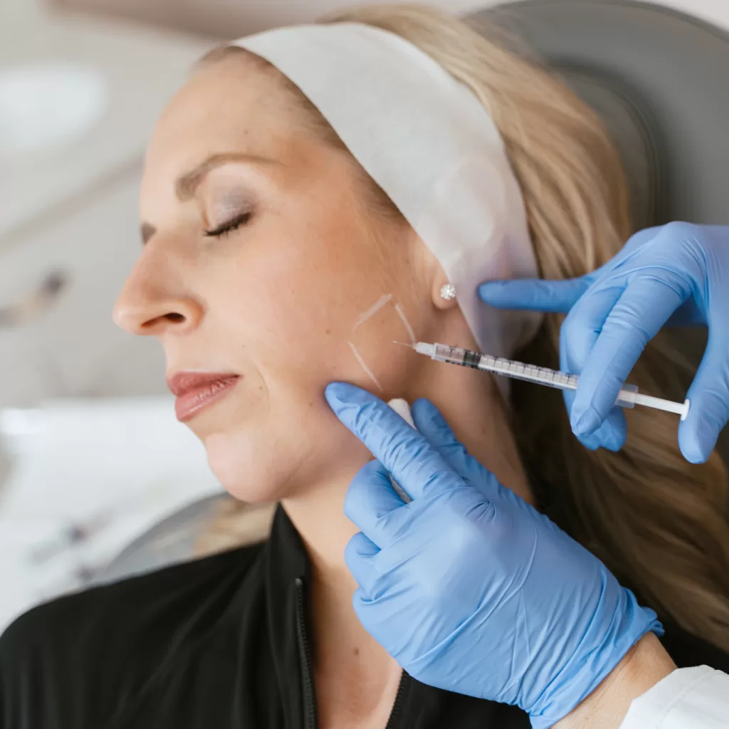 female patient receiving Botox injection into masseter muscle