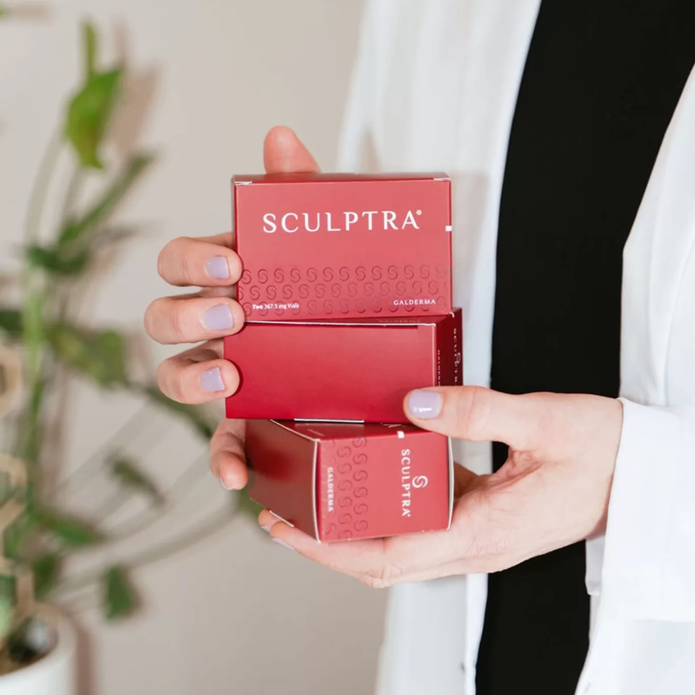 Close up of person holding packages of Sculptra