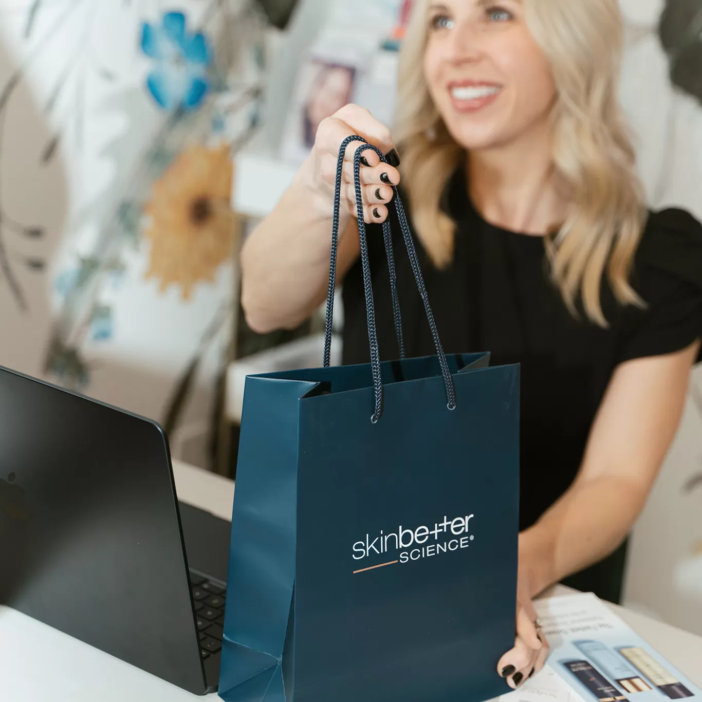 Female holding a bag of SkinBetter products