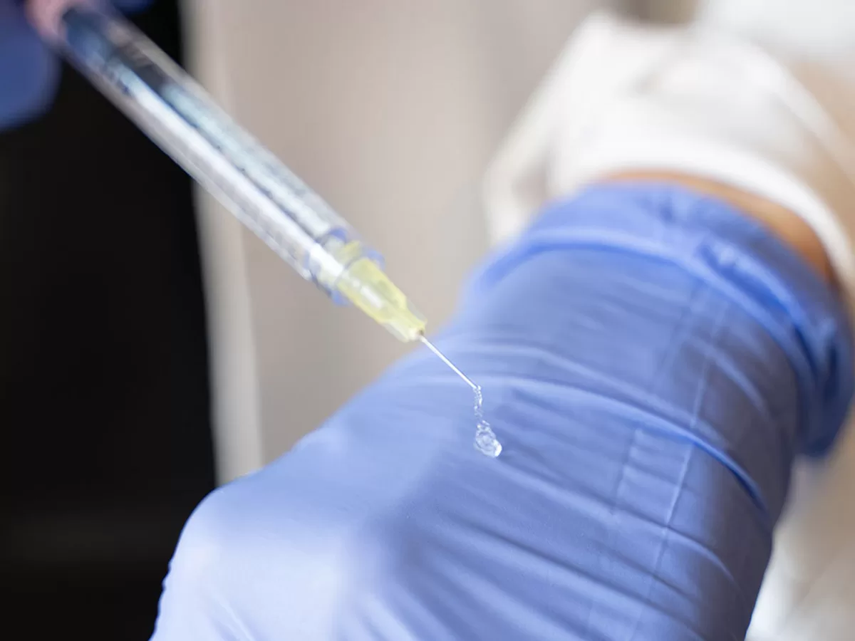 injection specialist showing what filler thickness looks like by placing some on top of hand