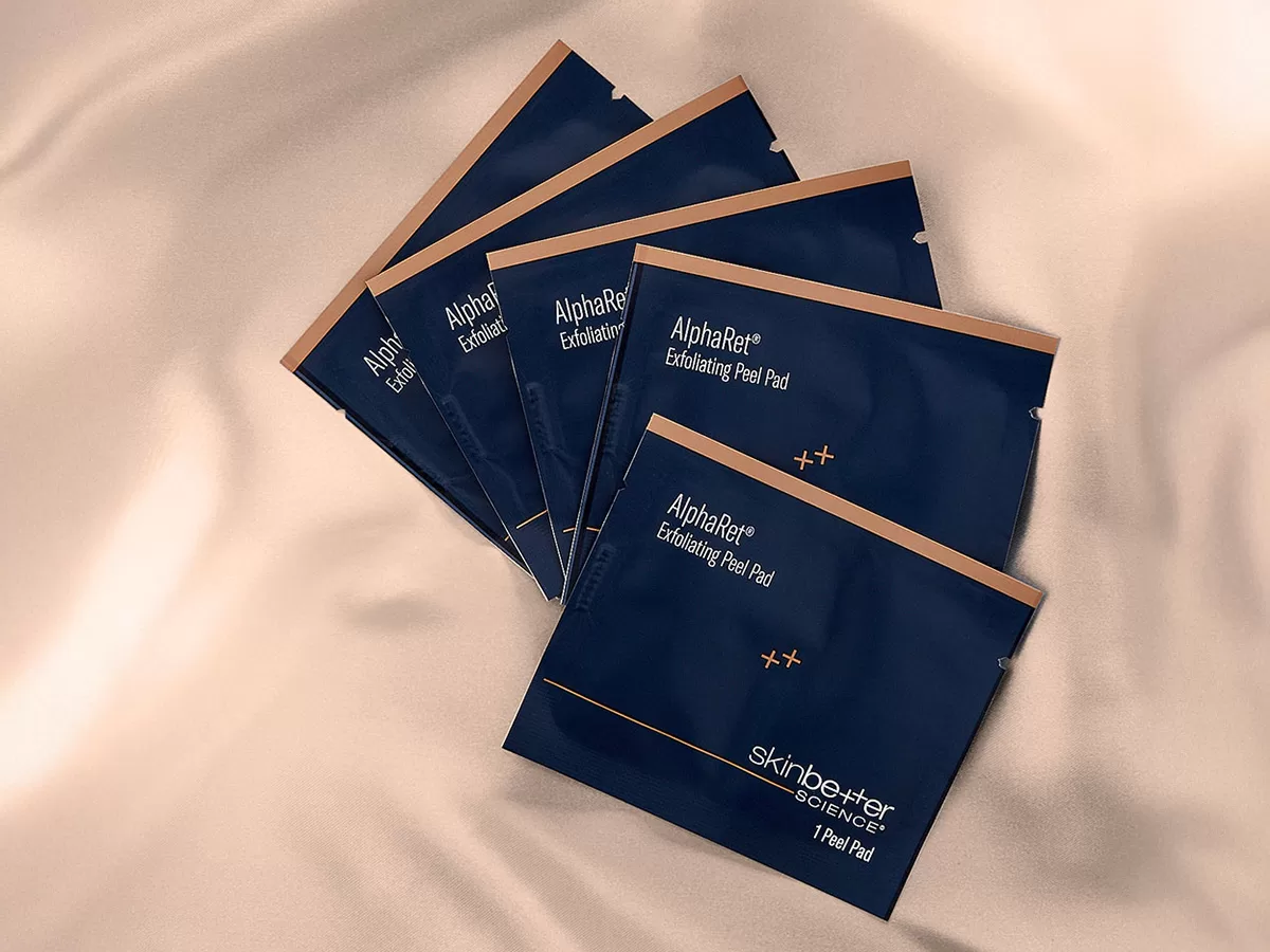 photo of 5 individually package AlphaRet peel pads on top of a satin sheet