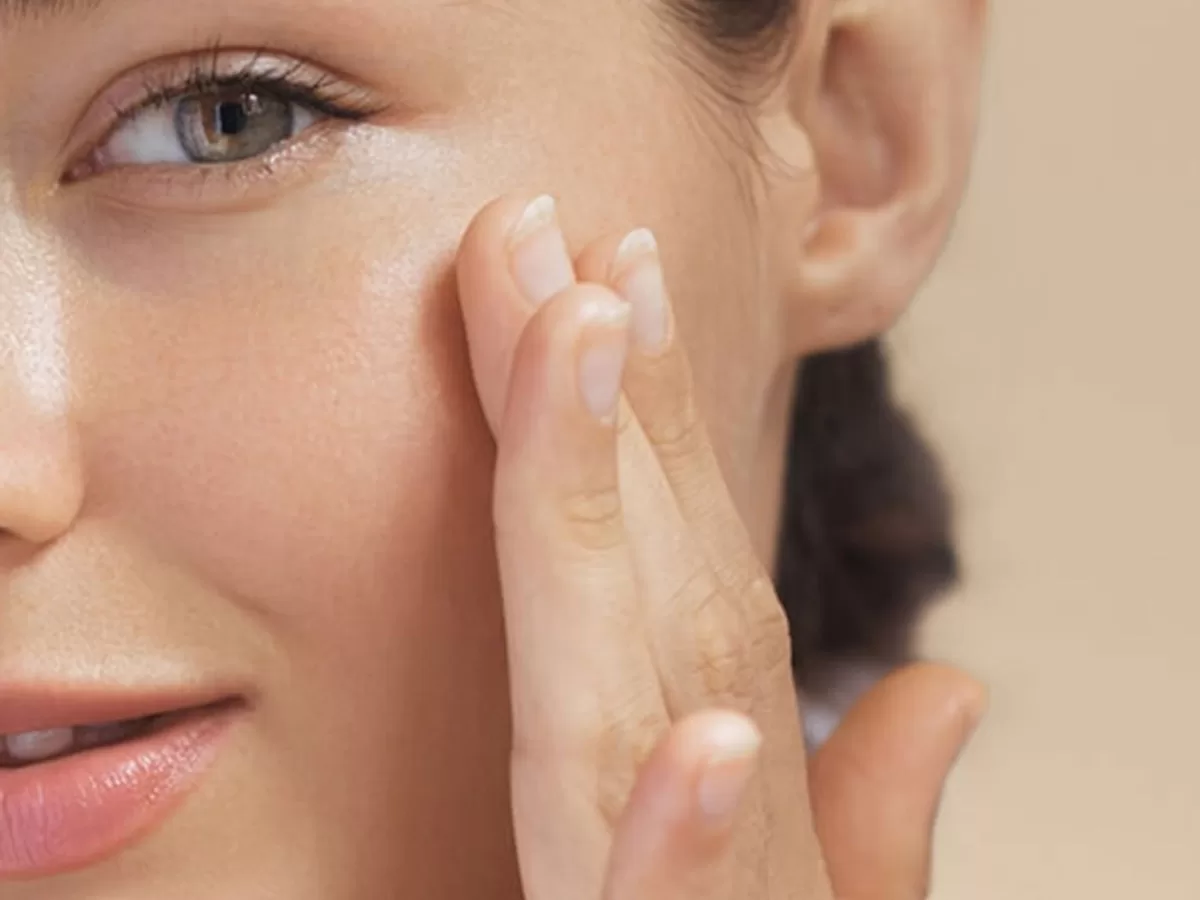 close of up female applying skincare to face